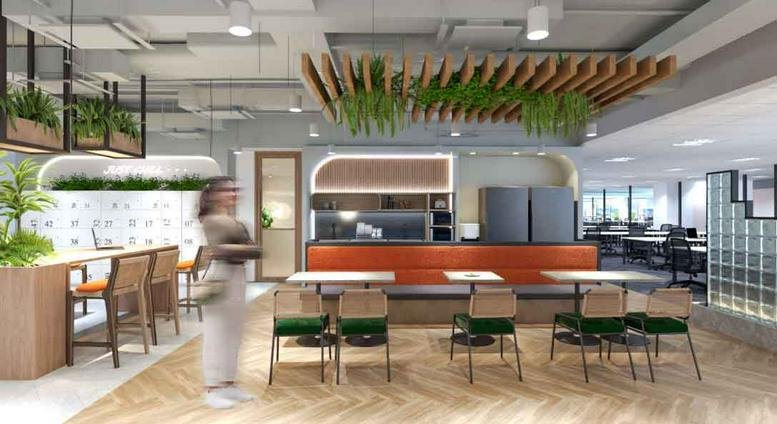 Spacious communal lounge and cafe area at Surian Tower with wood flooring and hanging greenery.