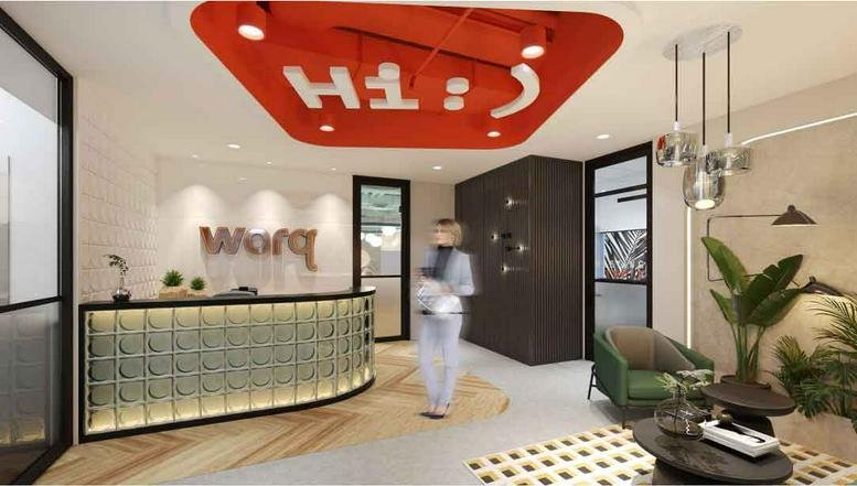 Modern lobby and reception area at Surian Tower, Level 12 featuring a glass-brick desk and bold red ceiling.
