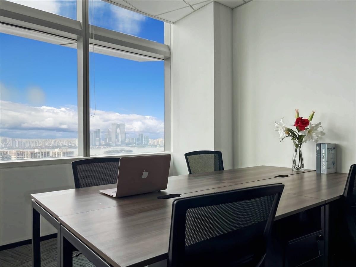Meeting room with a large wooden table and city skyline views at Tower 1, Jinghope Plaza.