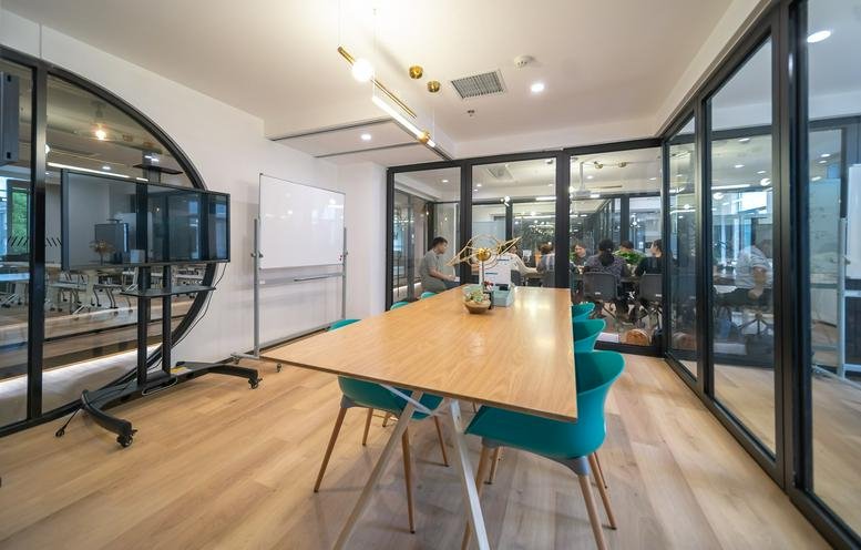 Spacious meeting room at Number 2, Beijing West Road, Gulou District, Nanjing with wood table and teal chairs.