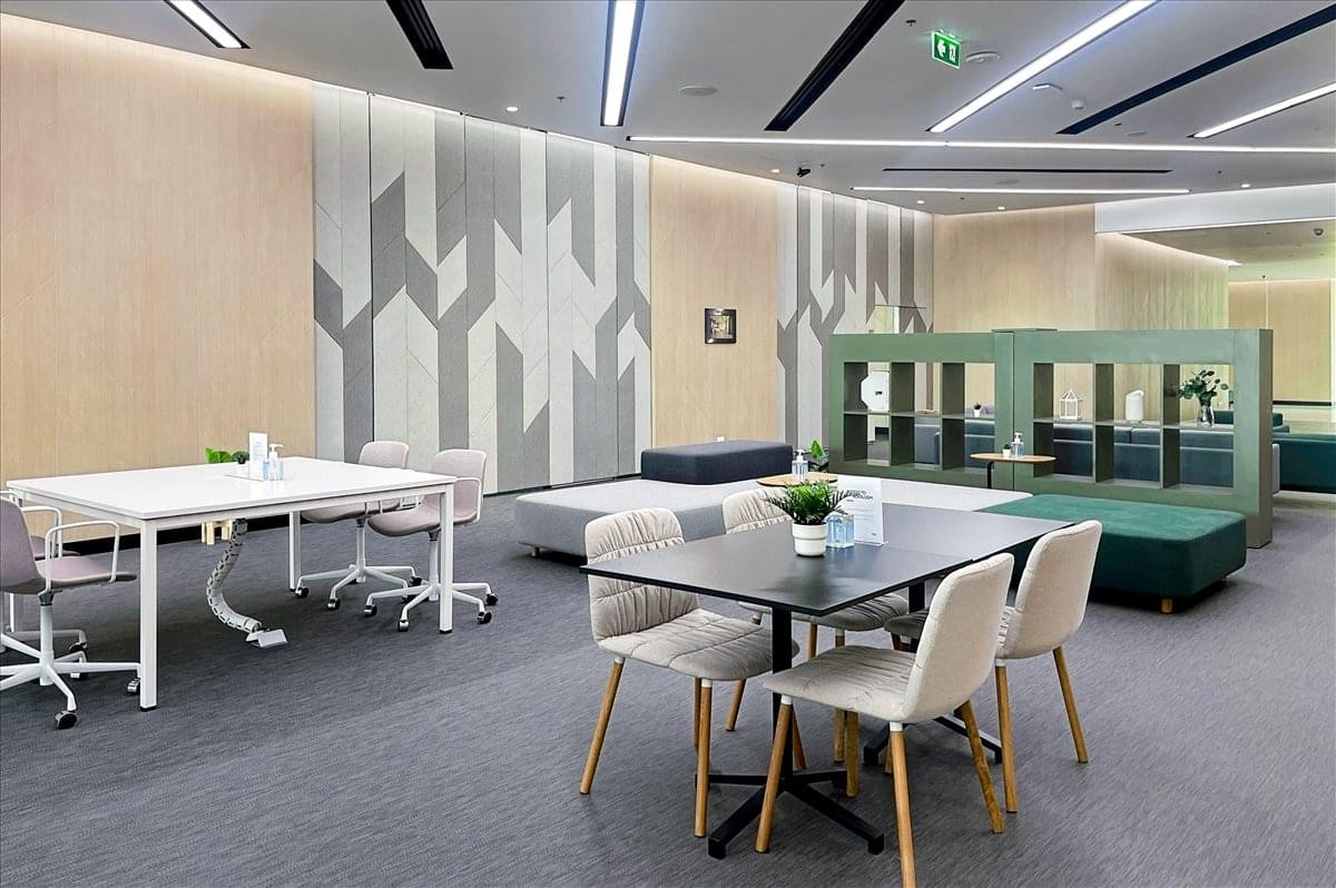 Open-plan coworking space with a geometric feature wall and diverse seating.