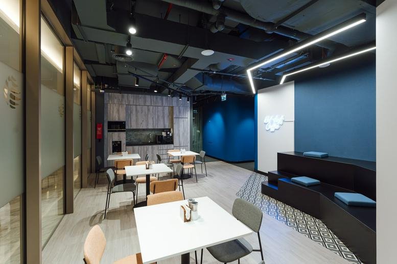 Modern café area at The Offices 2, One Central, with tiered seating and blue feature wall.