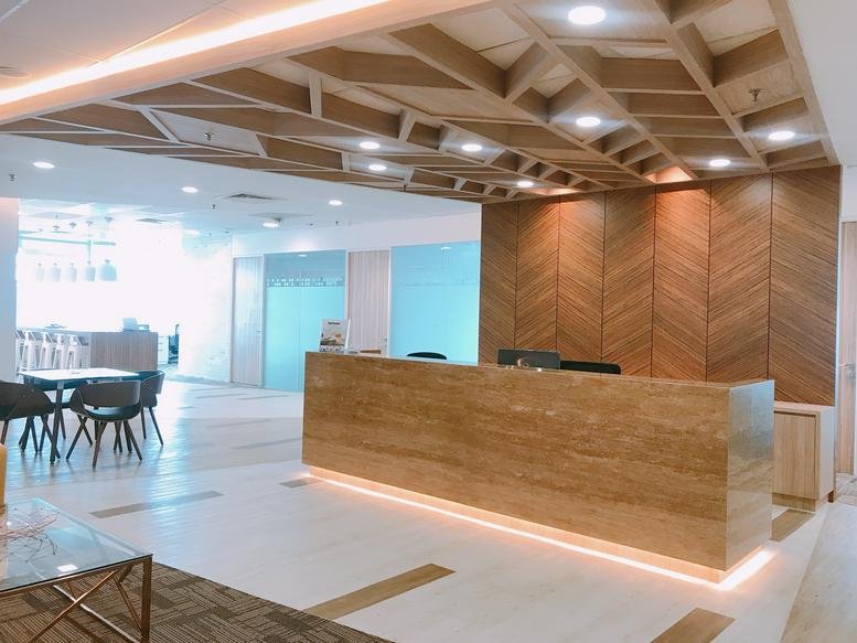 Spacious reception area at Axiata Tower, Level 31, KL Sentral, featuring a marble desk and wood-slat ceiling.