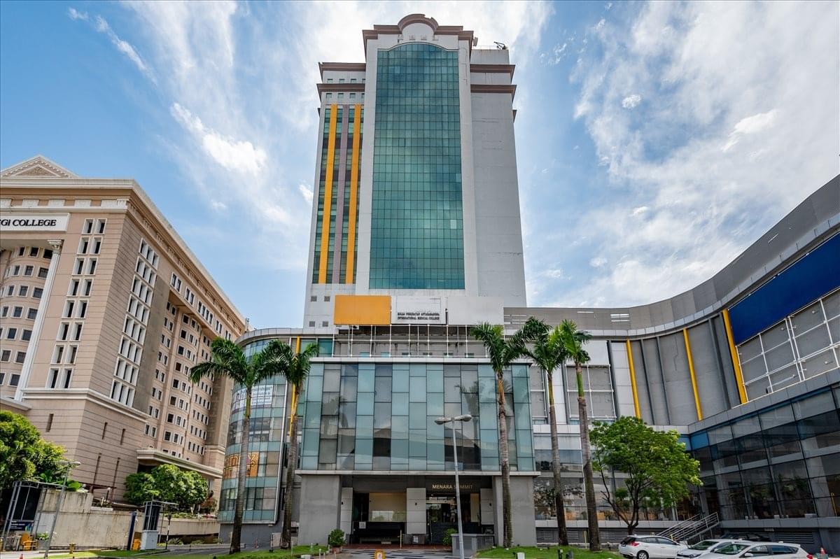 Exterior view of the high-rise Menara Summit featuring a green glass facade and commercial podium.