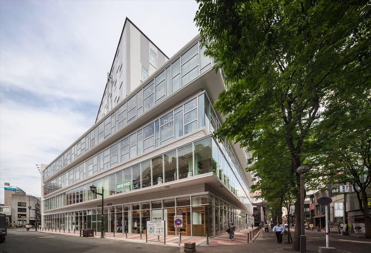 Exterior view of the glass-facade Shimotori NS Building in Kumamoto.