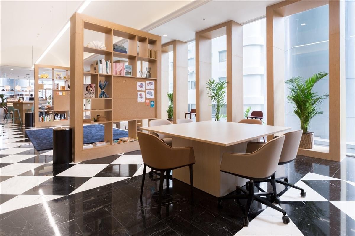 Spacious communal lounge at Empire Tower with checkered floors, bookshelves, and modern seating.