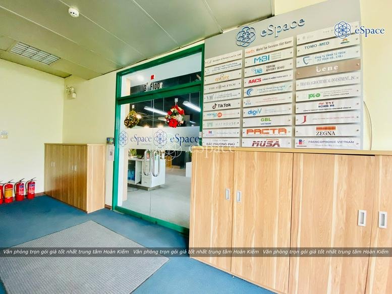 Reception area featuring a wooden cabinet, directory board with company logos, and fire extinguishers.
