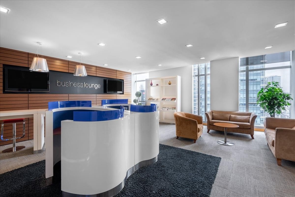Contemporary breakout lounge with stylish white and blue furniture and leather armchairs.
