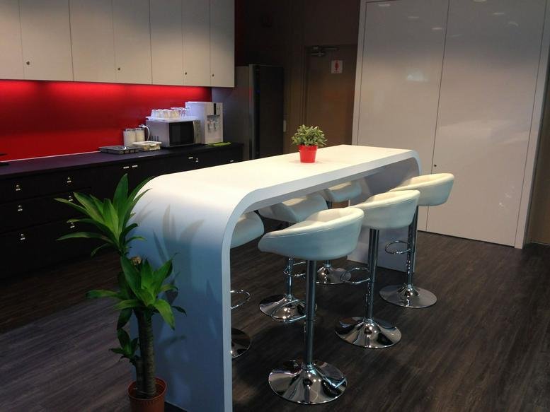 Modern pantry area with a white curved bar counter and high-backed white stools.