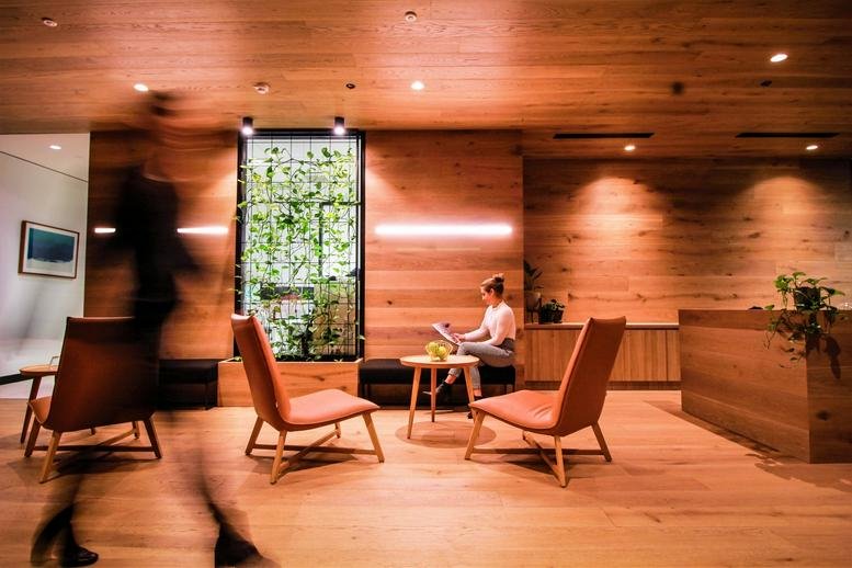 Warm, wood-paneled lobby area at Level 13, 111 Elizabeth Street with modern lounge chairs and indoor plants.