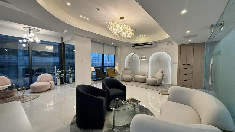 Elegant lounge area with curved white and blue velvet armchairs and arched wall niches.