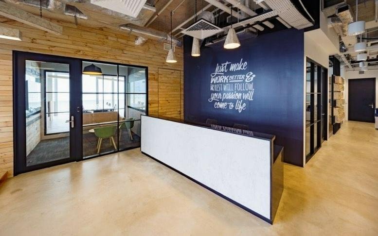 Reception area at 120 Robinson Road with a sleek white front desk and a navy blue feature wall.
