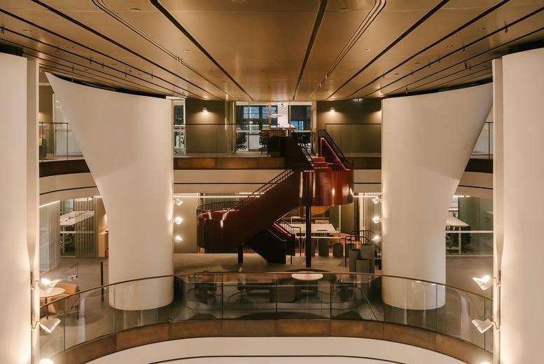 Grand lobby entrance at 121 Castlereagh Street, Level 12 with a sculptural staircase and tall white pillars.