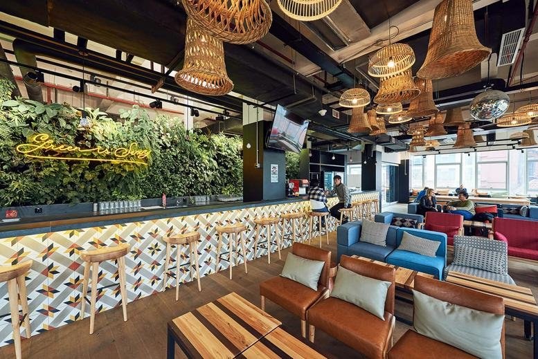 Spacious communal lounge at 1237 Fuxing Middle Road, Shanghai with a plant wall and wicker pendant lights.