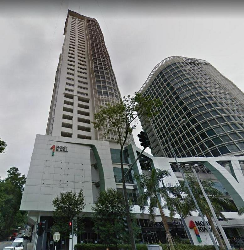 Exterior wide-angle street view of the tall white skyscraper and adjacent curved glass building.
