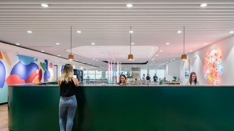 Spacious reception area at 161 Castlereagh Street, Sydney, with a green desk and vibrant wall art.
