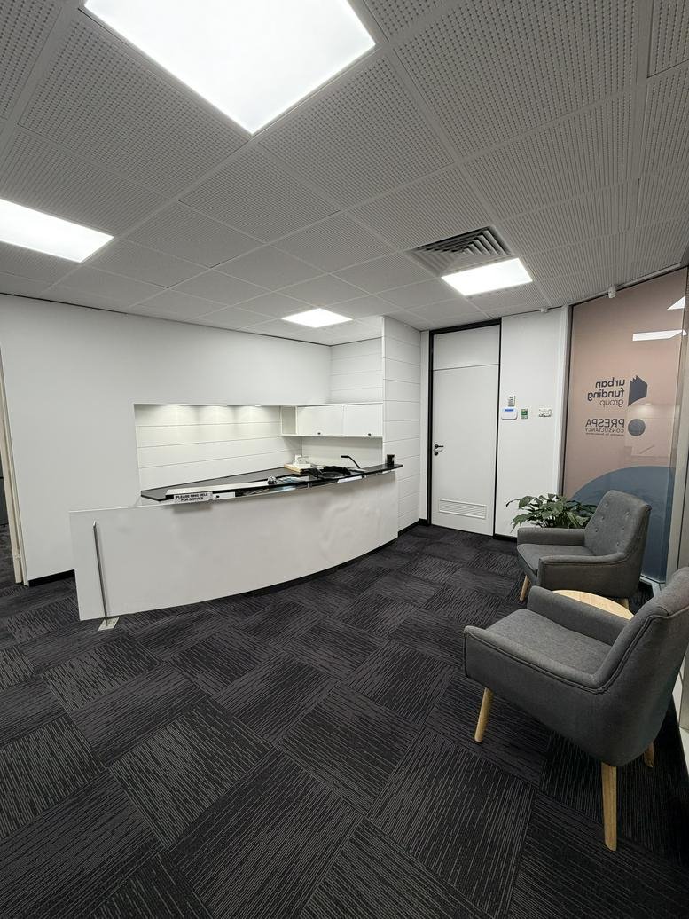 Modern lobby area with a sleek white counter and comfortable lounge seating.