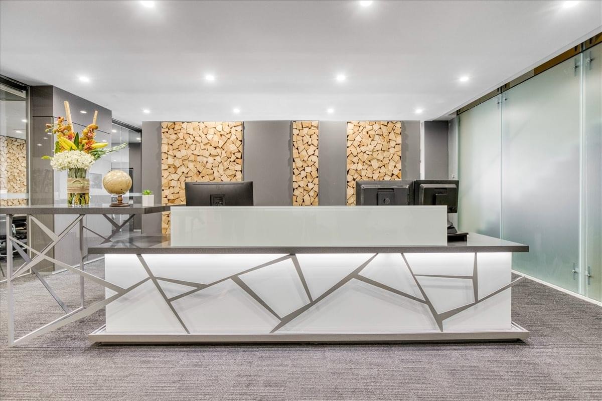 Modern reception desk at Level 19, 180 Lonsdale Street with geometric silver detailing and wood-stack feature walls.