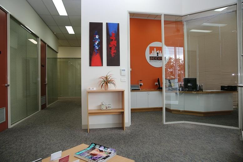 Bright reception area at 189-191 Balaclava Road, Caulfield with an orange feature wall and abstract art.