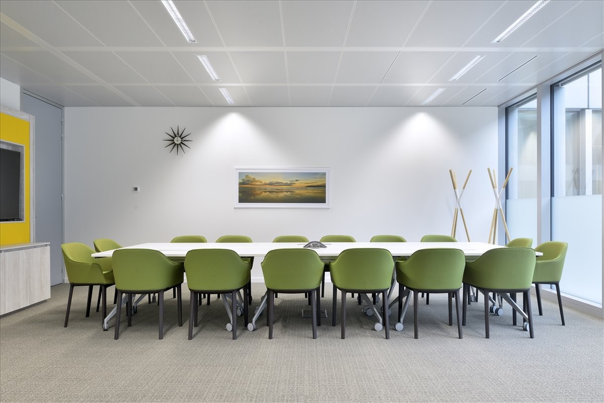 Spacious boardroom at No. 699 Shanghai Road, 1F&2F; with green armchairs and a long white conference table.