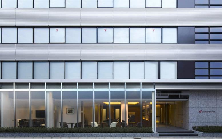 Exterior view of the multi-story modern office building at 2-10-3 Kojimachi, Chiyoda-ku, Tokyo.