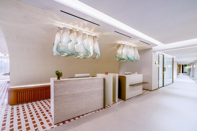 Spacious reception area at Levels 1, 2, 3, 4 & 5, Metro Blvd with wooden desks and glass art installations.