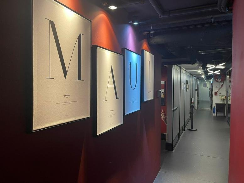 A stylishly lit hallway at Eton Tower featuring large 'MAUD' typographic wall art and red accent walls.