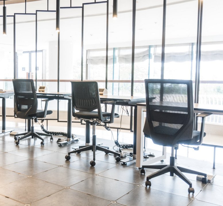 Sleek coworking area with black mesh chairs and glass partitions at Kerry Hotel Hong Kong, 2/F, 38 Hung Luen Road.