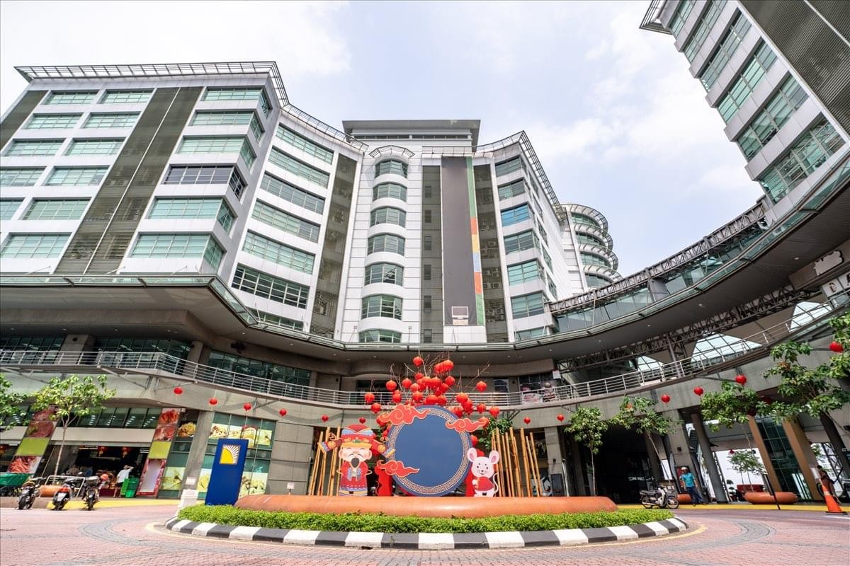 Exterior view of the Solaris Mont Kiara building with its modern multi-story facade and circular courtyard sculpture.
