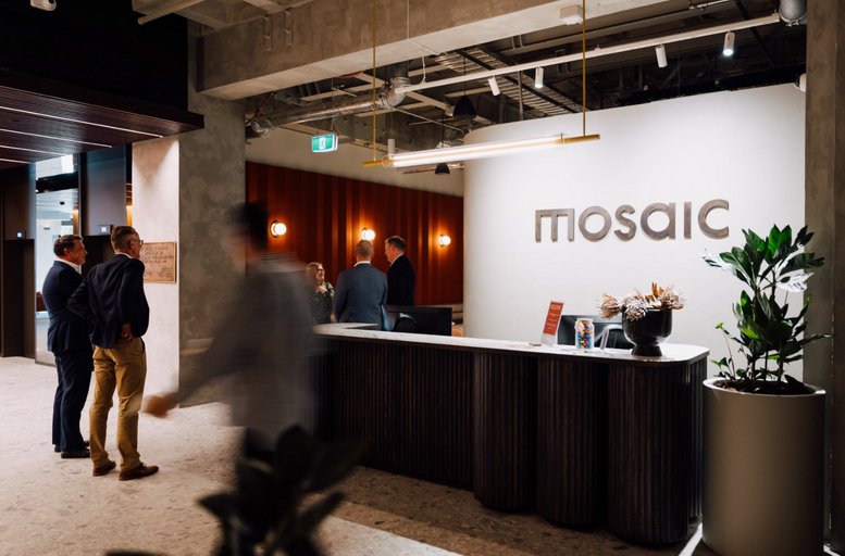 Spacious reception area with a curved wooden desk and branding for Mosaic at 2 Wakefield Street.