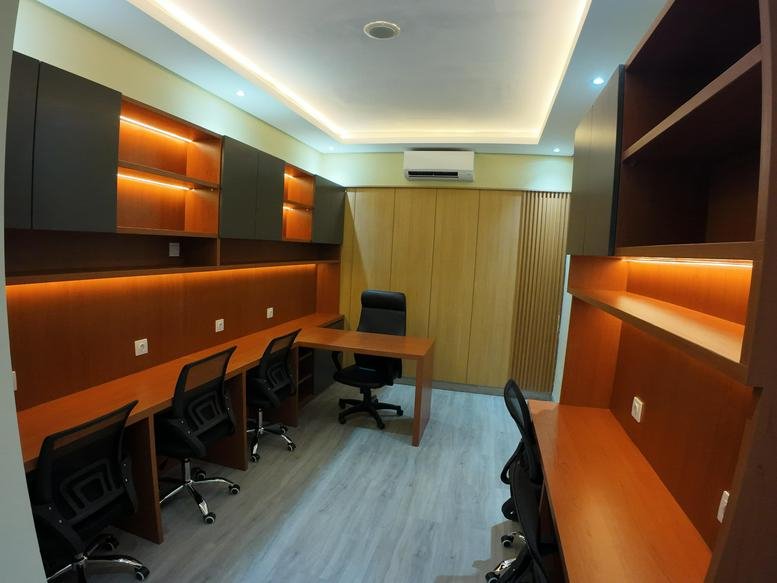 Shared office suite at The H Tower with warm wood paneling and multiple workstations.