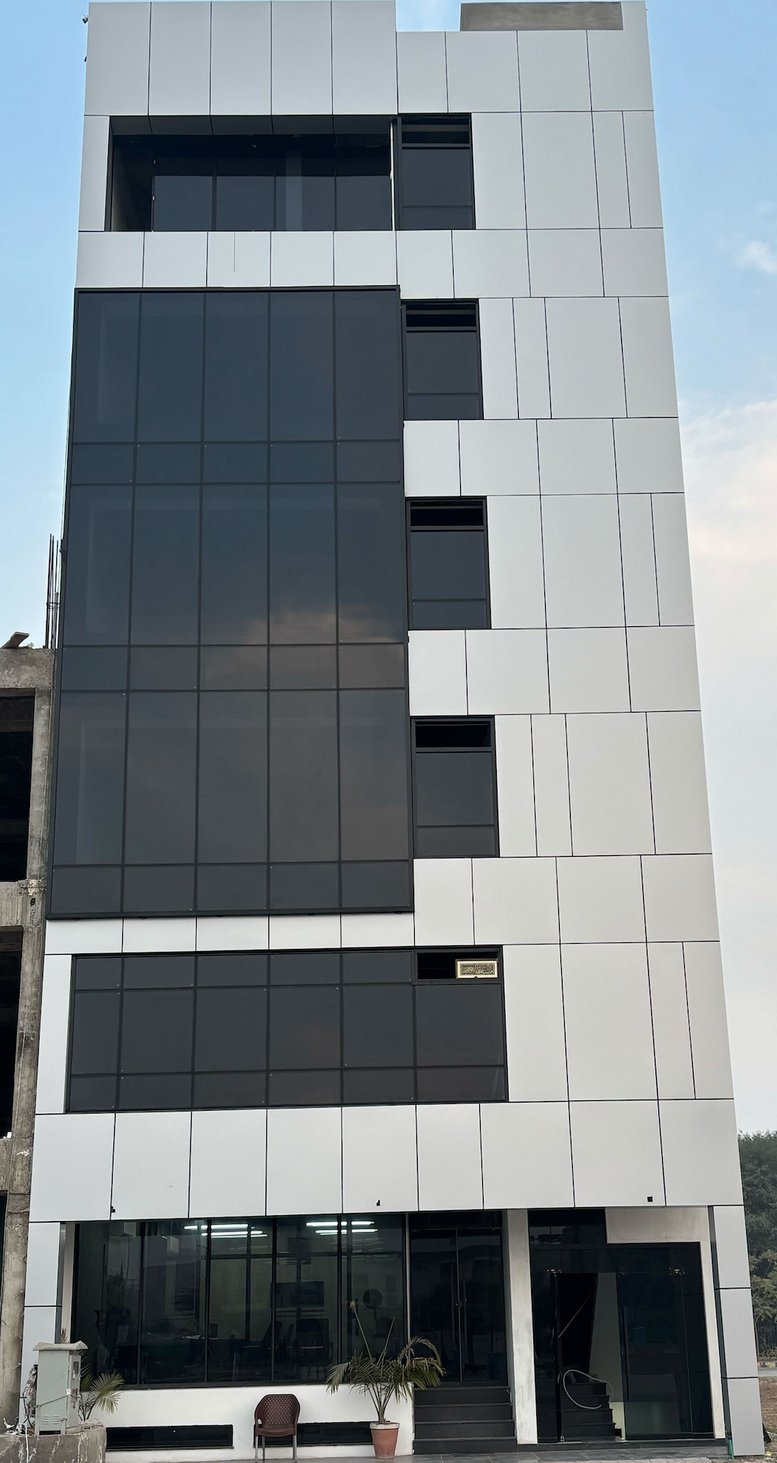 Exterior view of the modern white and glass facade at Prime Coworking, 200C, Etihad Town Phase-1.