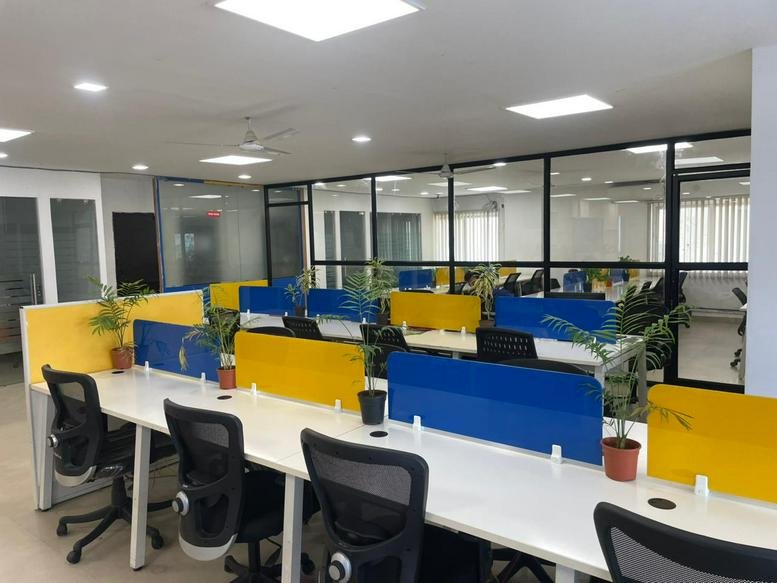 Wide view of the open-plan workspace at Shanmukh Empire with rows of desks and glass-walled private offices.