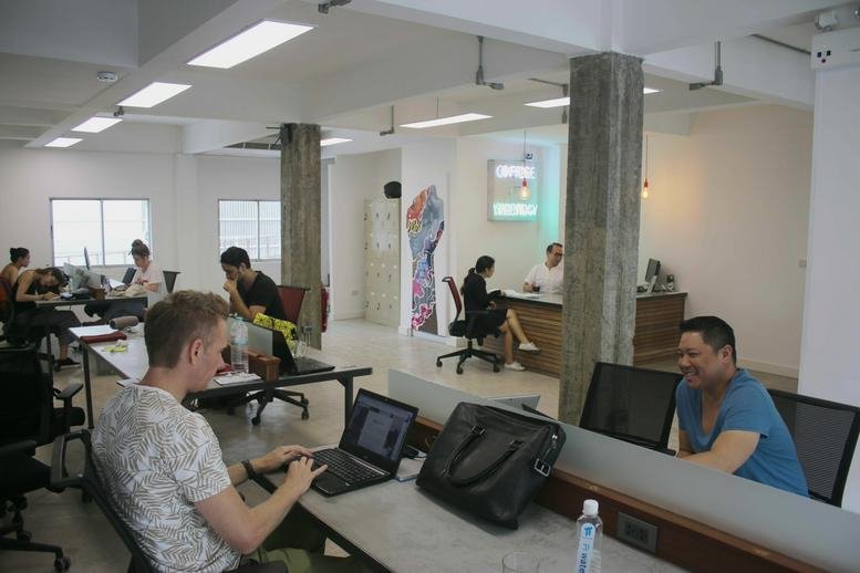 Lively open-plan office at 205/19-21 Thonglor Road, Sukumvit soi 55 with people working at desks.