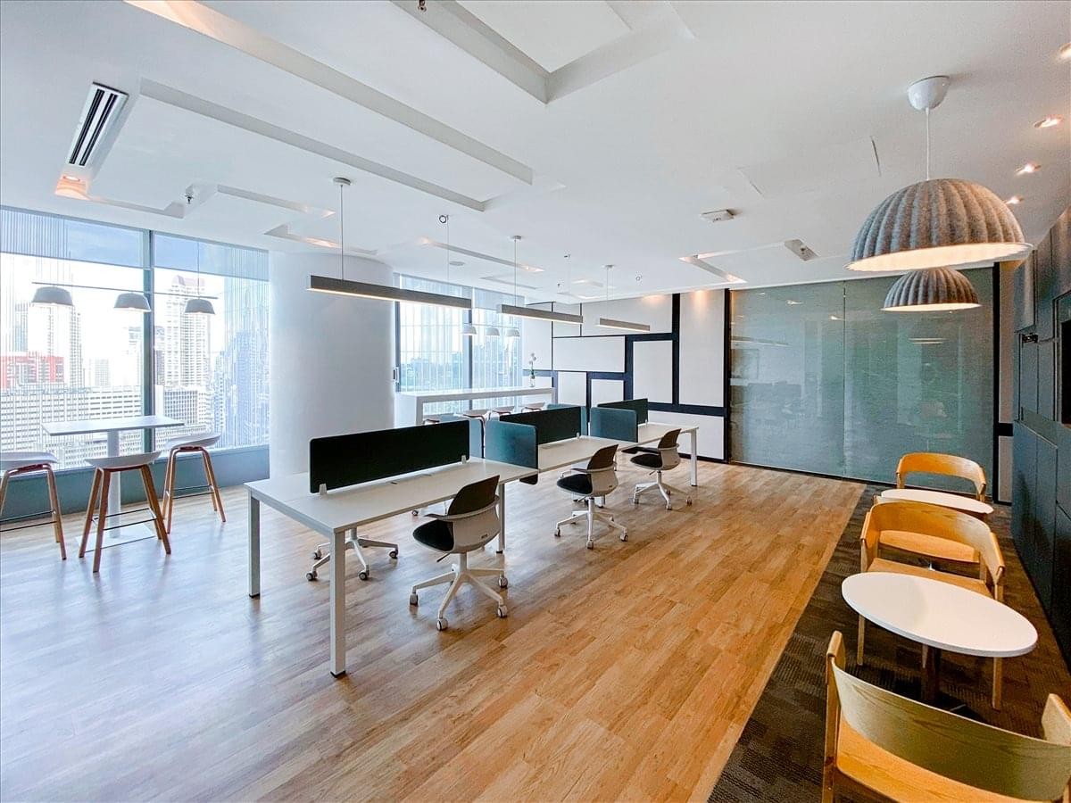 Bright, open-plan workspace with multiple workstations, warm wood floors, and city views.