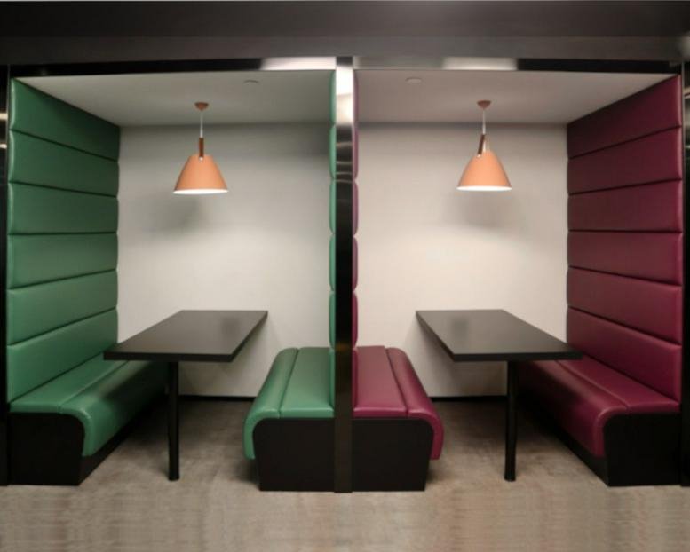 Matching green and burgundy meeting booths with overhead pendant lighting.