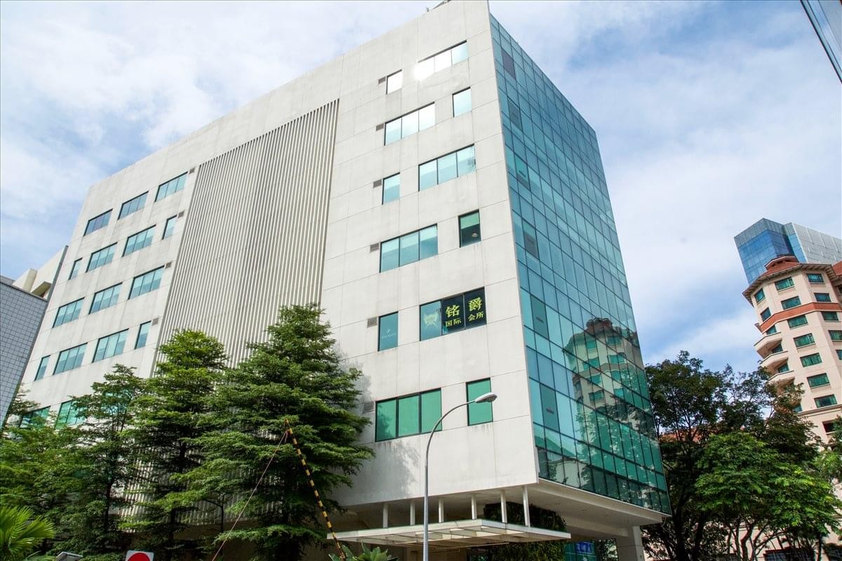 Exterior view of the modern glass and stone building at 21 Merchant Road, Clarke Quay.