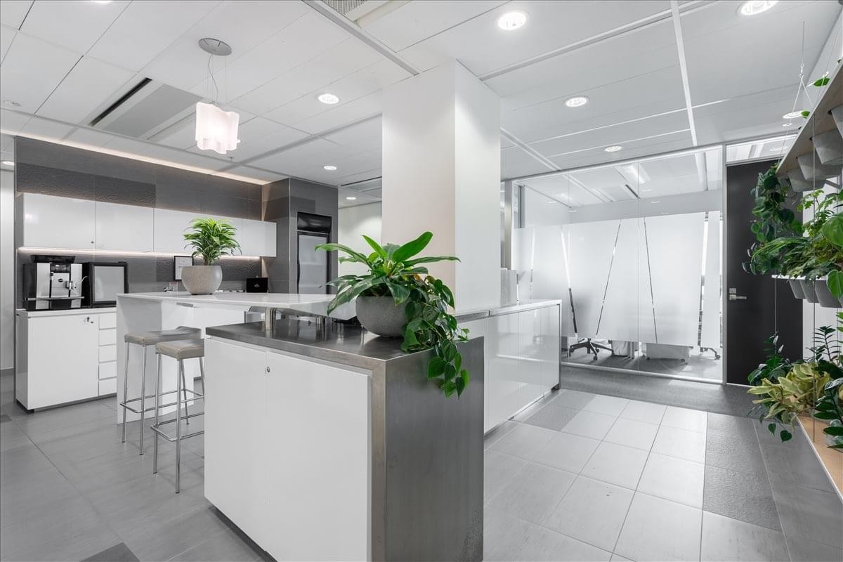 Modern communal kitchen and breakout area at 21 Queen Street, Auckland, New Zealand.