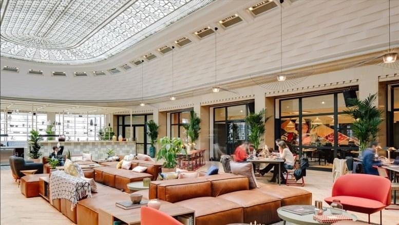 Spacious communal lounge at 219 Wangfujing Avenue featuring tan leather sofas under a large skylight atrium.