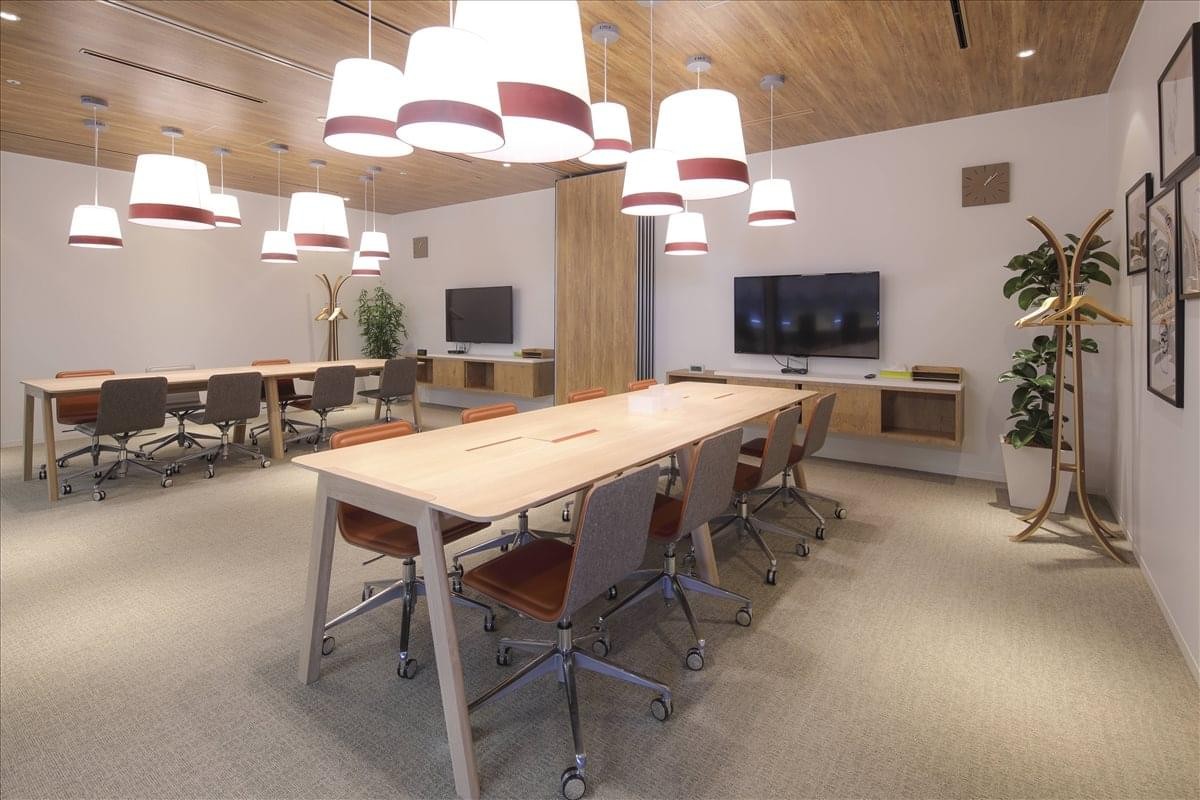 Modern coworking space with wood-paneled ceilings and diverse seating options.