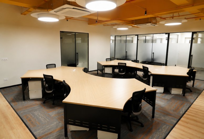 Spacious open-plan workspace at Amrakunj Business Centre, 221, New Chandkheda, Ahmedabad, India with clover-shaped desks.