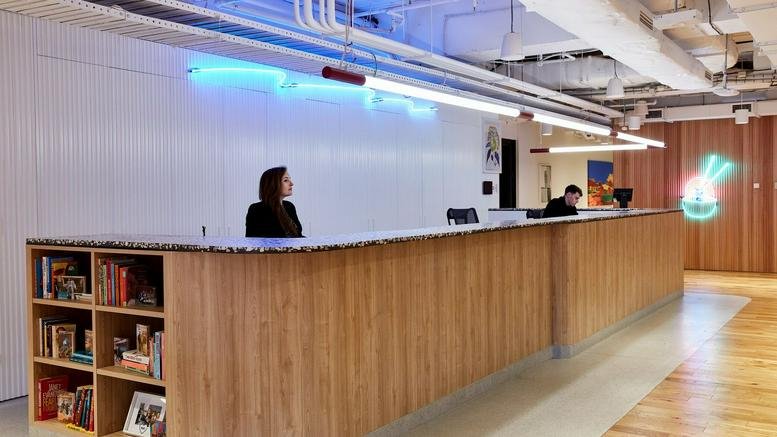 Reception area at 222 Exhibition Street, Melbourne, Victoria with wooden panelling and neon lighting.