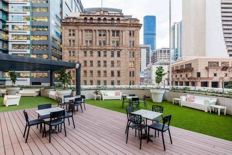 Rooftop terrace at 240 Queen St with outdoor seating and views of historic and modern skyscrapers.