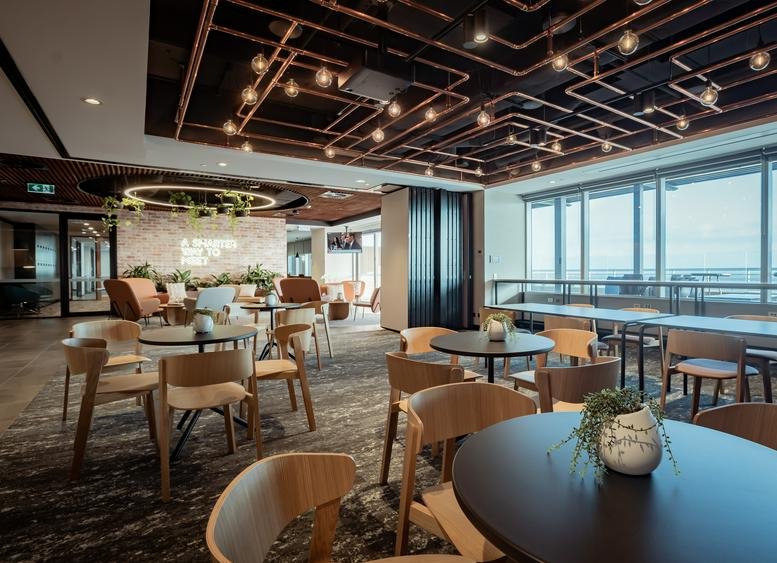 Spacious communal lounge at Dexus Place, Level 16, 240 Saint Georges Terrace with industrial ceiling and city views.