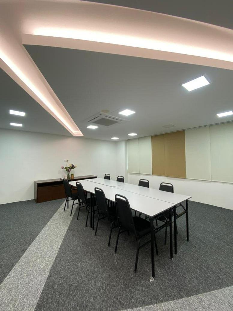 Professional board room at Co Base Workspace featuring a long white table and black chairs.