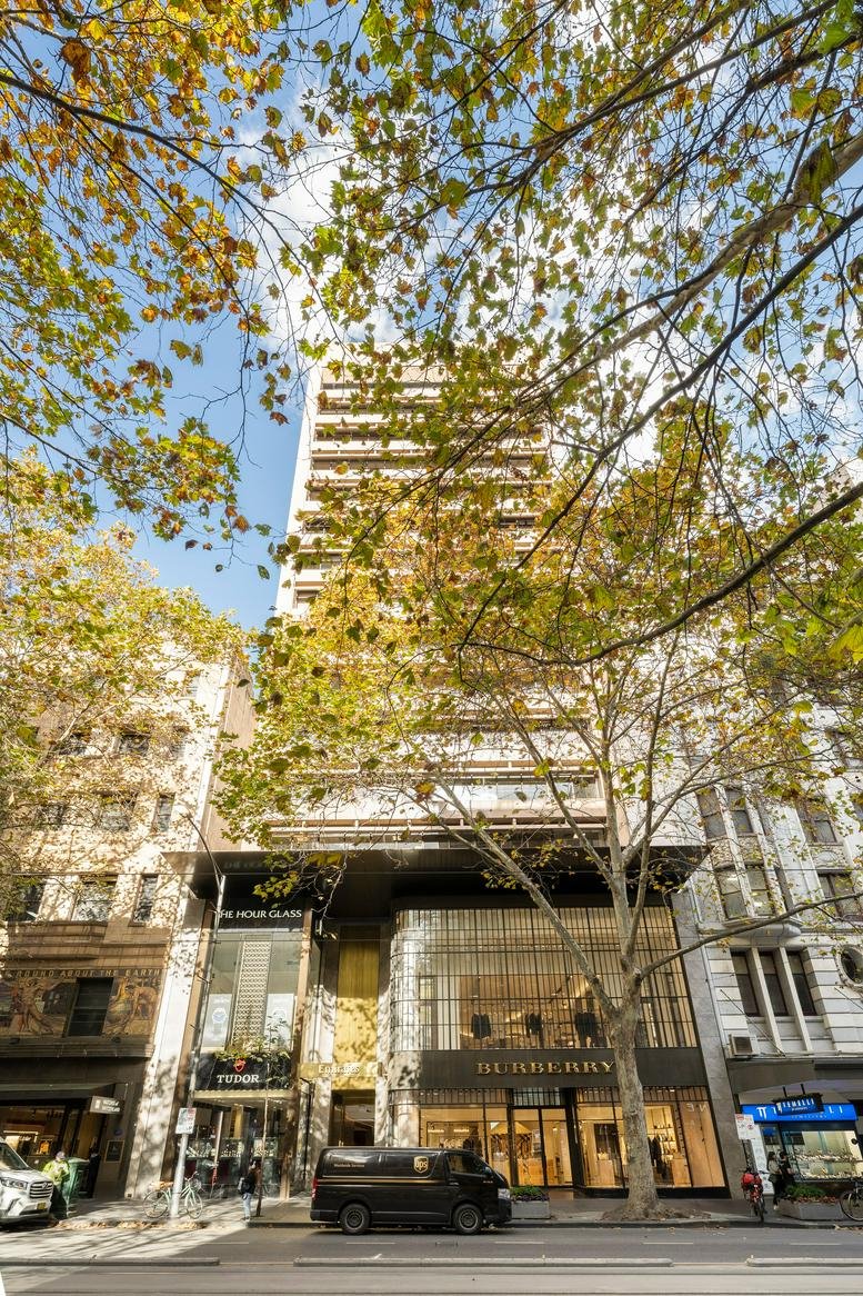 Exterior view of the multi-story heritage building at 257 Collins Street framed by autumn trees.
