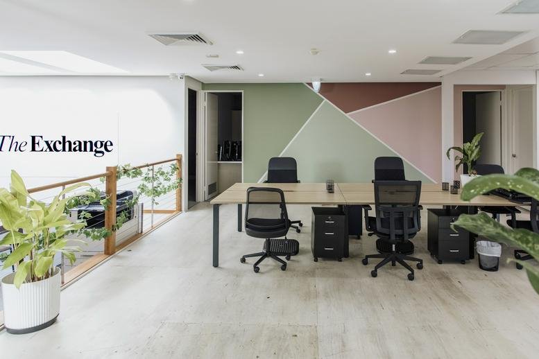 Spacious open-plan workspace at The Exchange Noosa with a geometric feature wall and indoor plants.