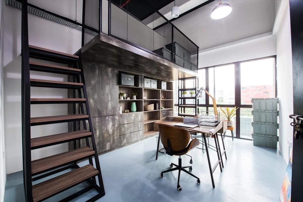 Spacious industrial-style creative office at 2Connectt@TS featuring a mezzanine and floor-to-ceiling windows.