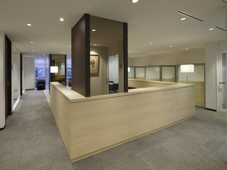 Spacious reception area at Ueno Building 2 featuring a modern wood-paneled desk and warm recessed lighting.