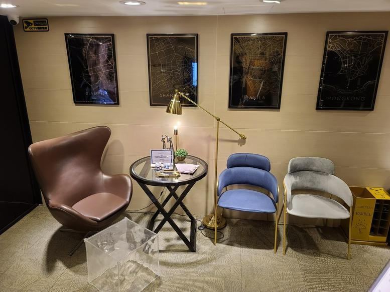 Spacious lounge at Eton Tower with eclectic seating, a glass table, and framed wall art.